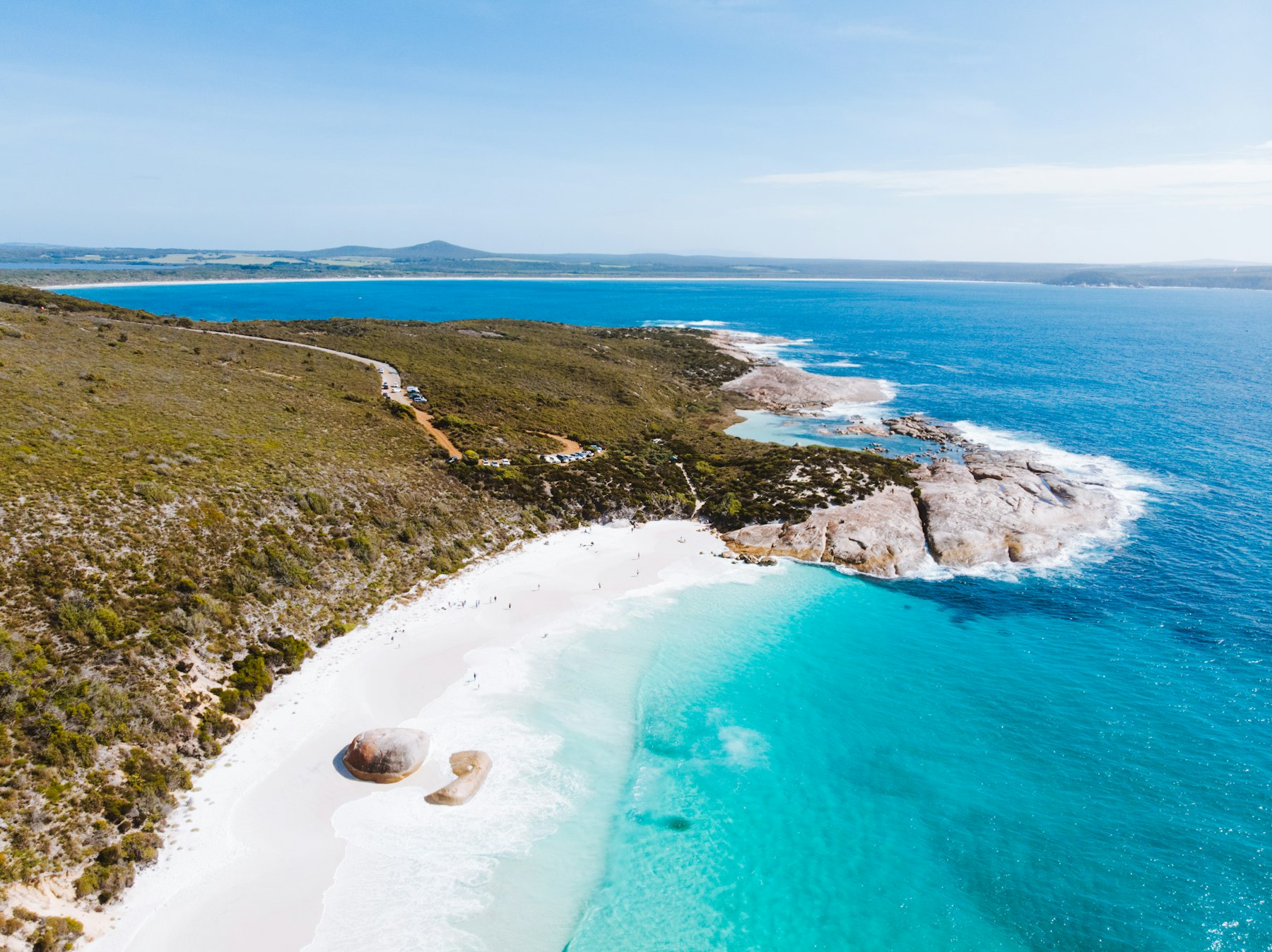 Aerial view of a sandy shoreline and blue water on the south coast