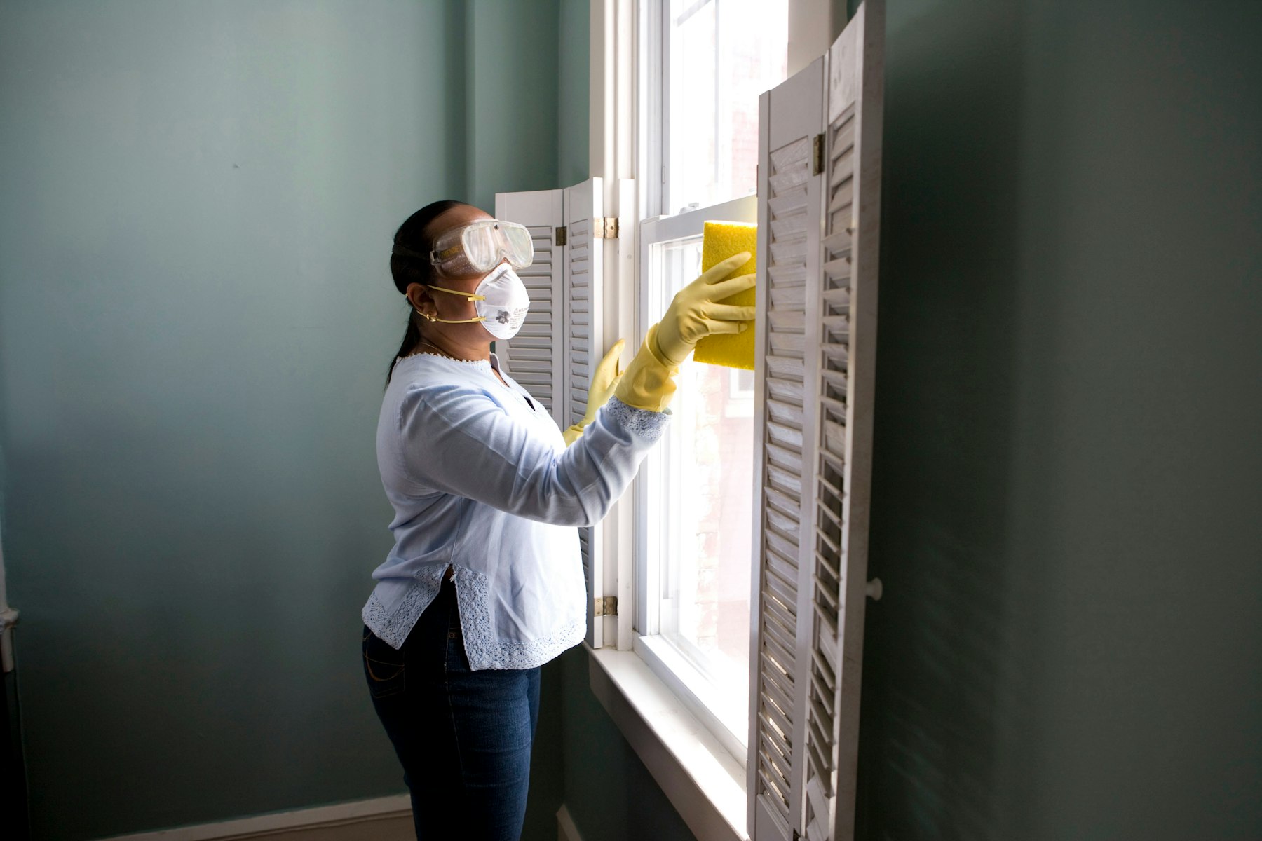 Cleaner wiping down a kitchen bench