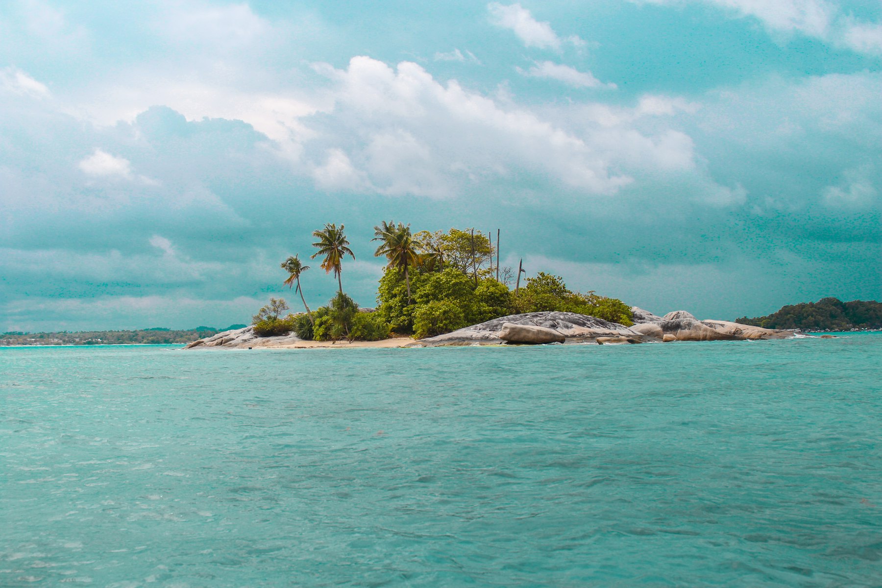 View across water to a long low island on the horizon