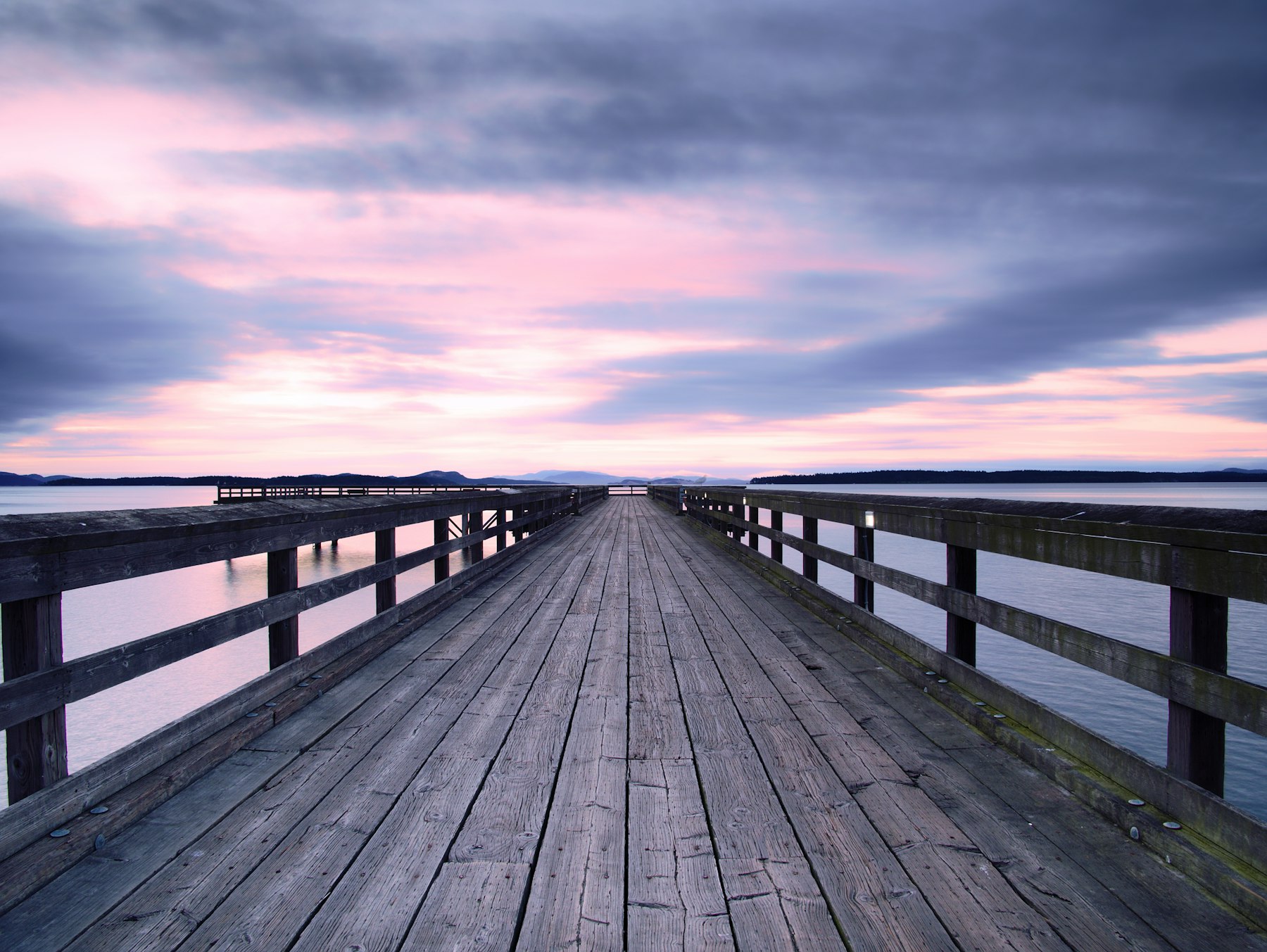 Timber jetty stretching into calm water