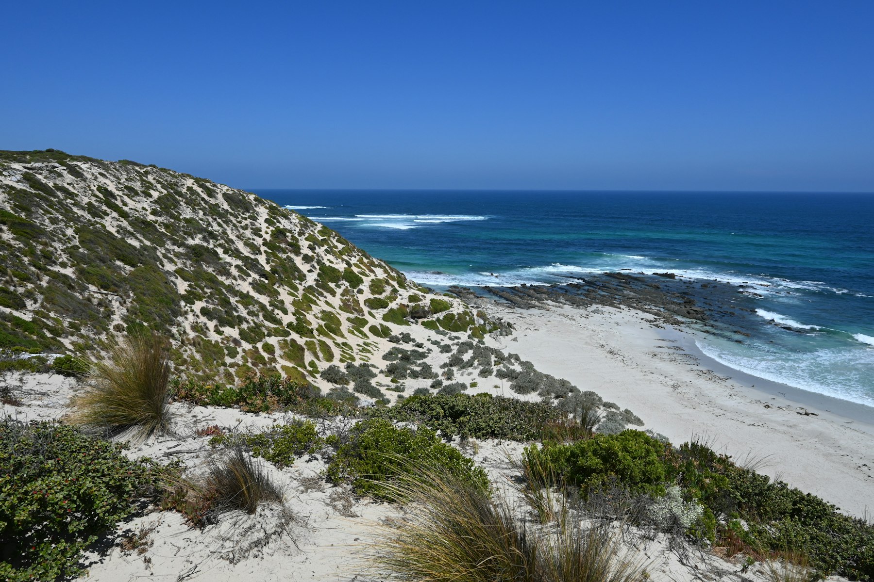 Quiet sandy beach with gentle surf on a clear day