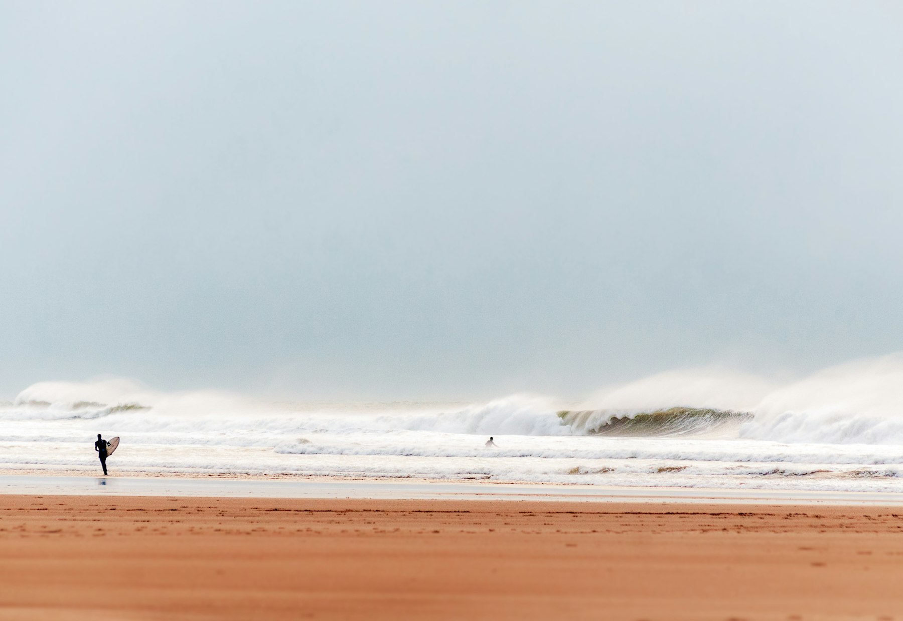 Rolling surf breaking along a long beach