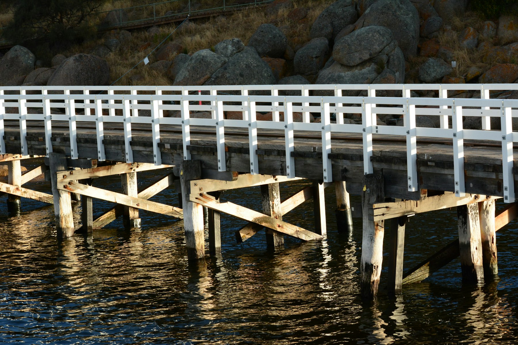 Wooden causeway stretching across calm water on the south coast